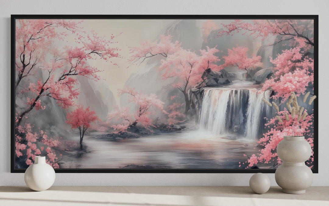 Framed canvas wall art of a grey waterfall and blush pink cherry blossoms in a serene landscape.