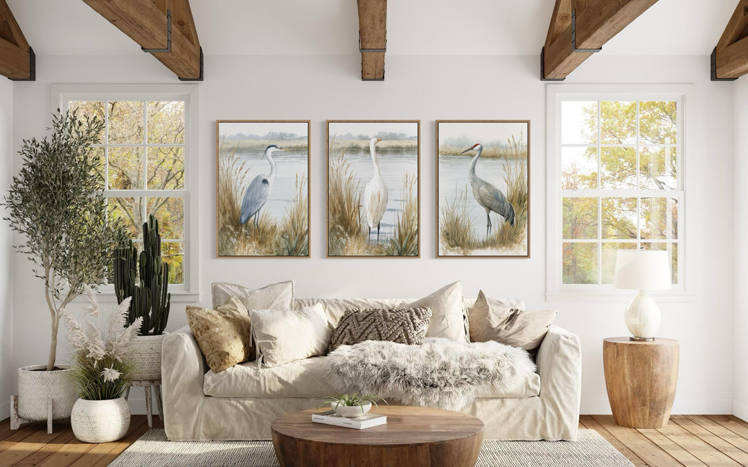 A triptych of heron, egret, and crane prints in a neutral boho coastal living room.