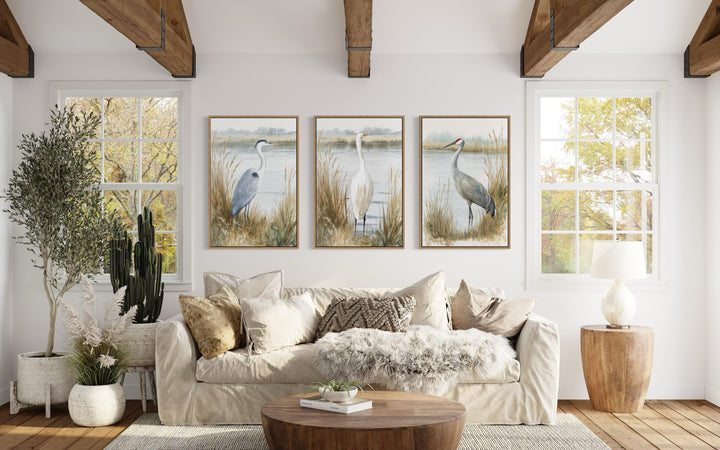 A triptych of heron, egret, and crane prints in a neutral boho coastal living room.