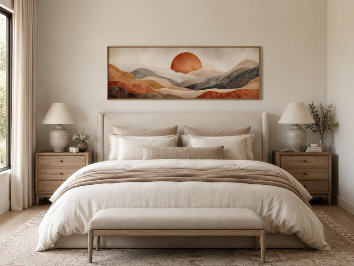 Long horizontal boho desert canvas wall art with terracotta sun and hills above a neutral bed.