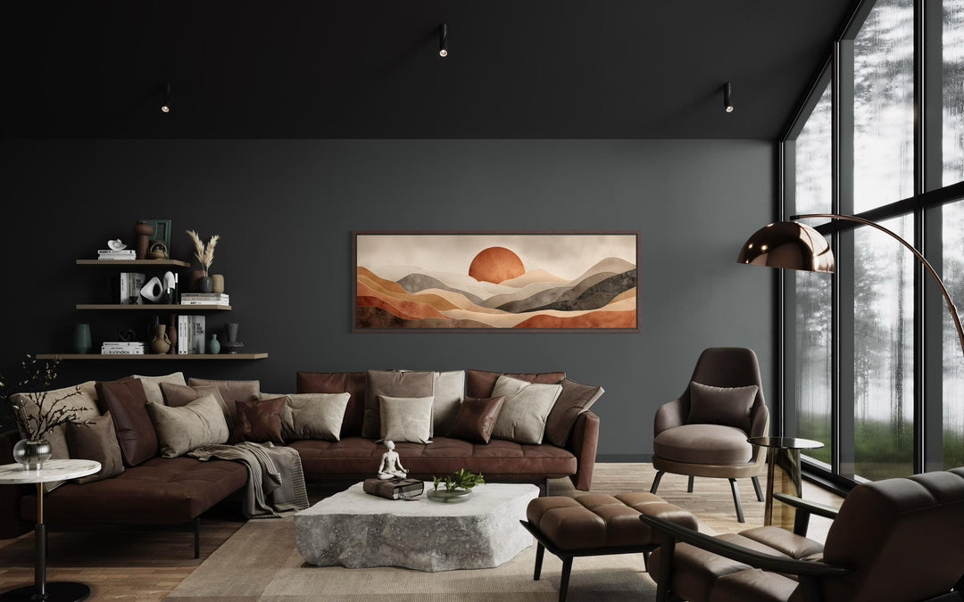 Long horizontal canvas print of a boho desert landscape with a terracotta sun above a dark sofa.