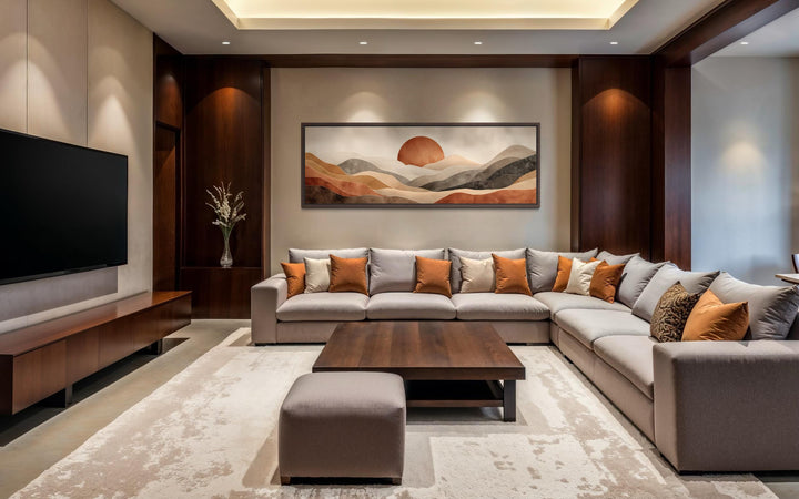 Boho desert landscape wall art with terracotta sun and rolling hills above a large sectional sofa.