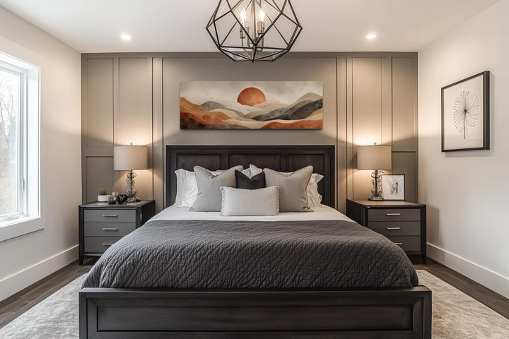 Boho desert landscape canvas wall art with terracotta sun above a dark wood bed in a modern bedroom.