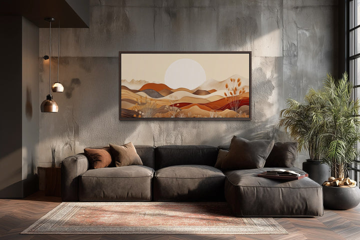 Boho desert mid-century landscape framed canvas art above a dark sofa in a modern living room.