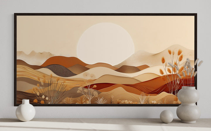 Framed boho desert landscape canvas art with rolling dunes and mountains in neutral earth tones.