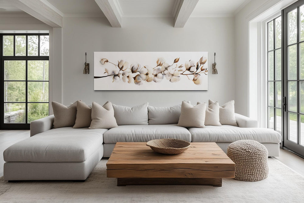 Long horizontal canvas wall art featuring neutral cotton plant painting above a modern sofa.