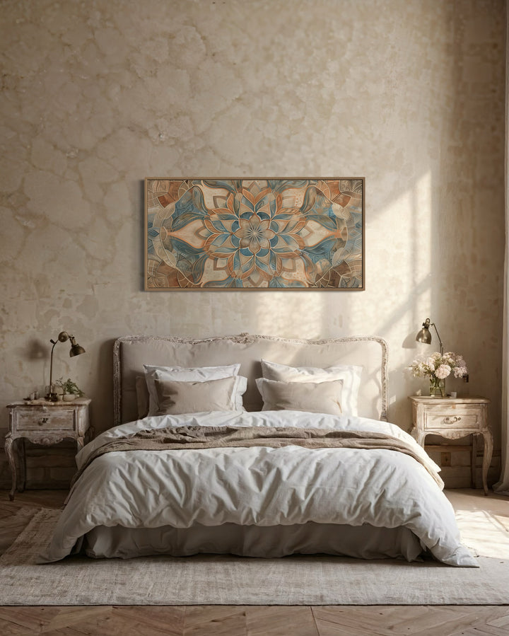 Large framed boho mandala canvas wall art in blue and earth tones hanging above a bed.