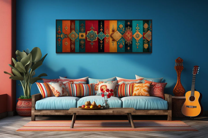 Boho Moroccan long horizontal colorful geometric wall art above a blue sofa with patterned pillows.