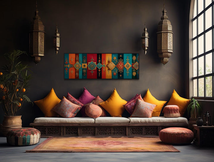 Boho Moroccan long horizontal colorful geometric wall art above a sofa with vibrant pillows.