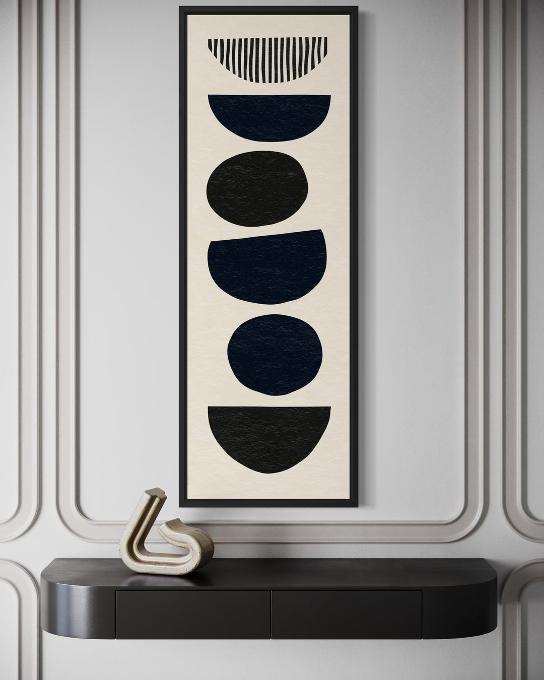 Boho stacked stones tall narrow black neutral canvas wall art in a black frame on a grey wall.