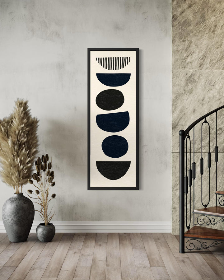 Tall narrow canvas wall art featuring black abstract stacked stone shapes on a neutral background.