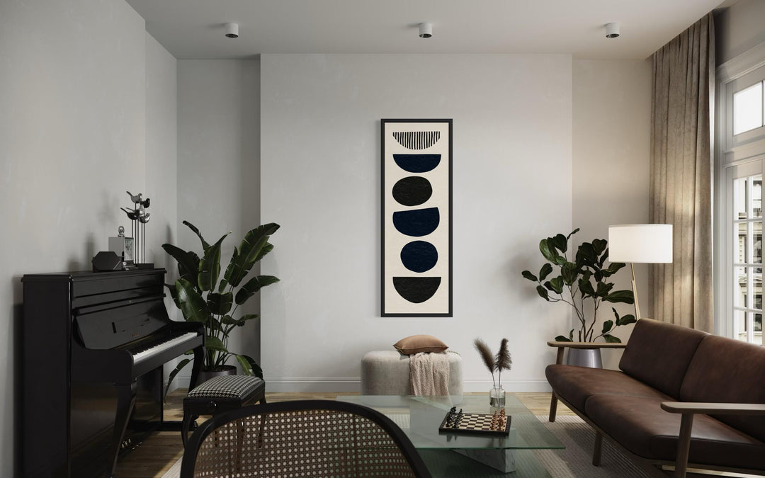 Boho stacked stones tall narrow black and neutral canvas wall art in a modern living room.