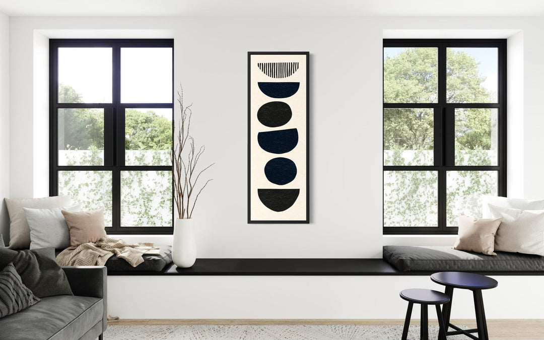 Boho stacked stones tall narrow black neutral canvas wall art in a modern living room.