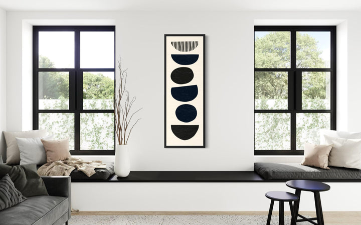 Boho stacked stones tall narrow black neutral canvas wall art in a modern living room.