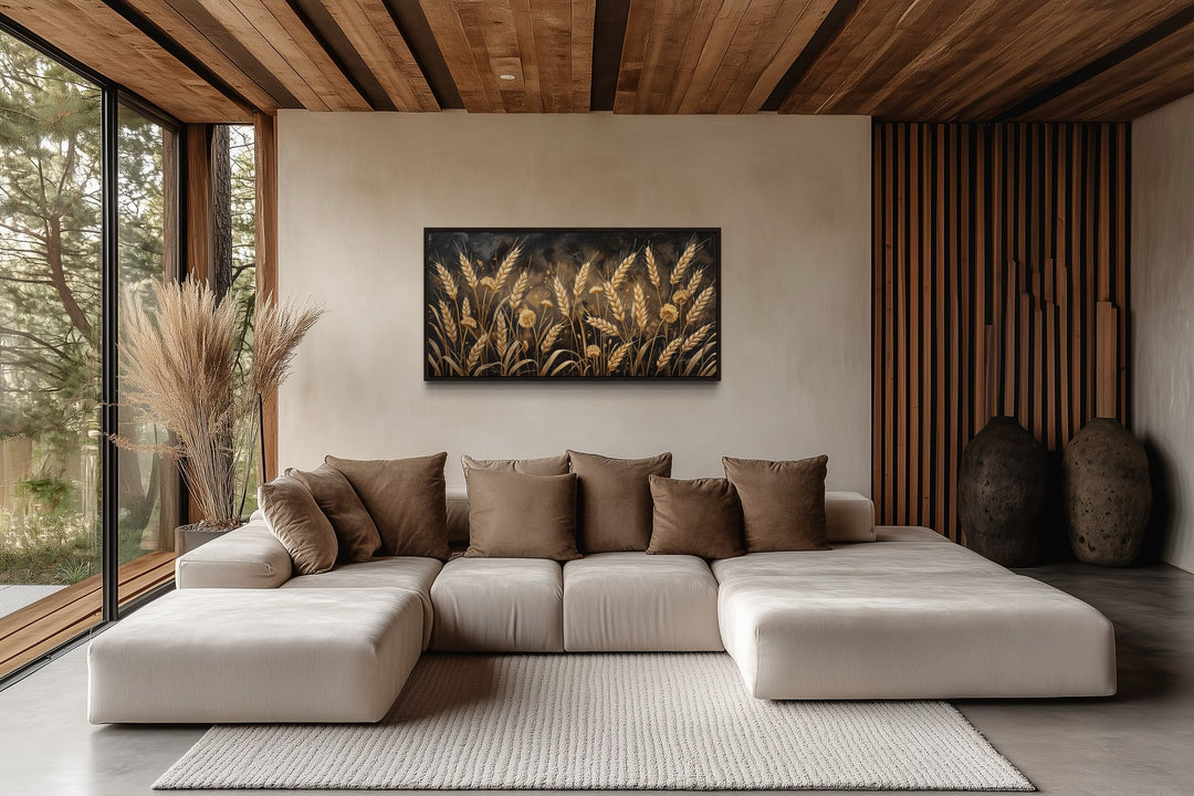 Framed canvas print of a golden wheat field hanging above a beige sectional sofa in a rustic room.
