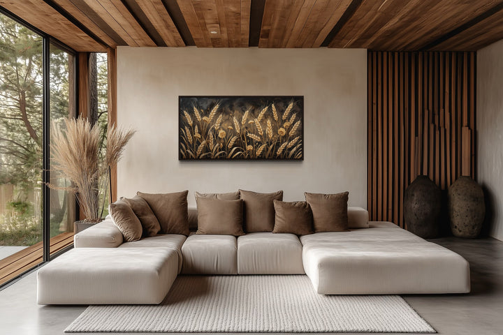 Framed canvas print of a golden wheat field hanging above a beige sectional sofa in a rustic room.