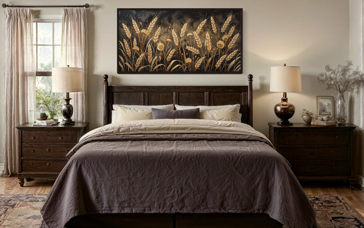 Framed canvas print of a boho wheat field in brown and beige tones hanging above a dark wood bed.
