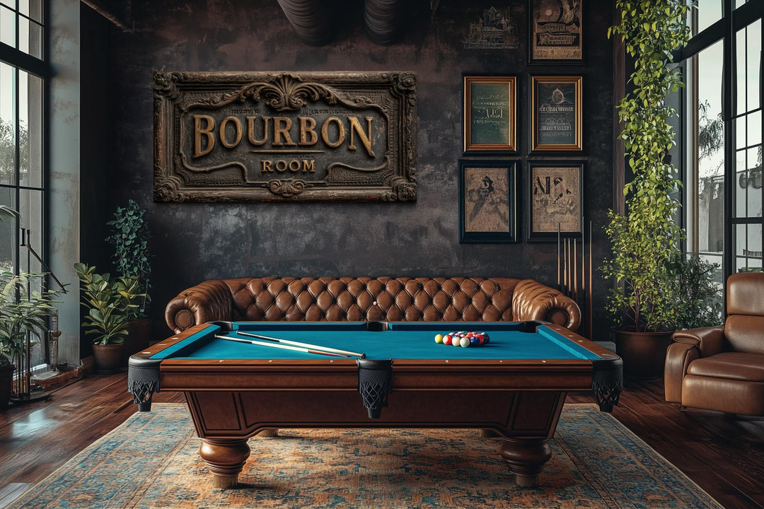 Rustic Bourbon Room wall art sign above a pool table in a dark, masculine man cave with leather sofa.