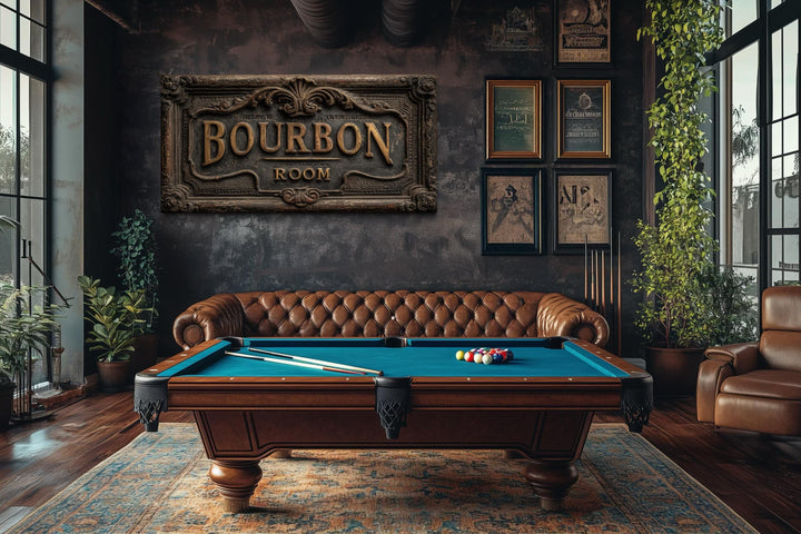 Rustic Bourbon Room wall art sign above a pool table in a dark, masculine man cave with leather sofa.