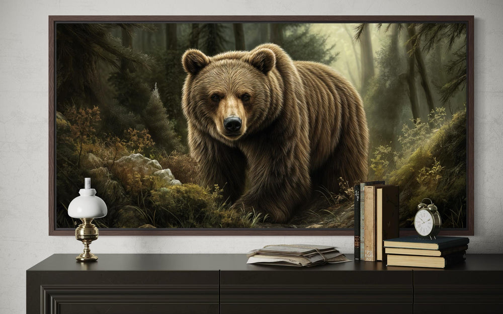A framed canvas print of a majestic brown bear walking through a misty forest above a dark dresser.