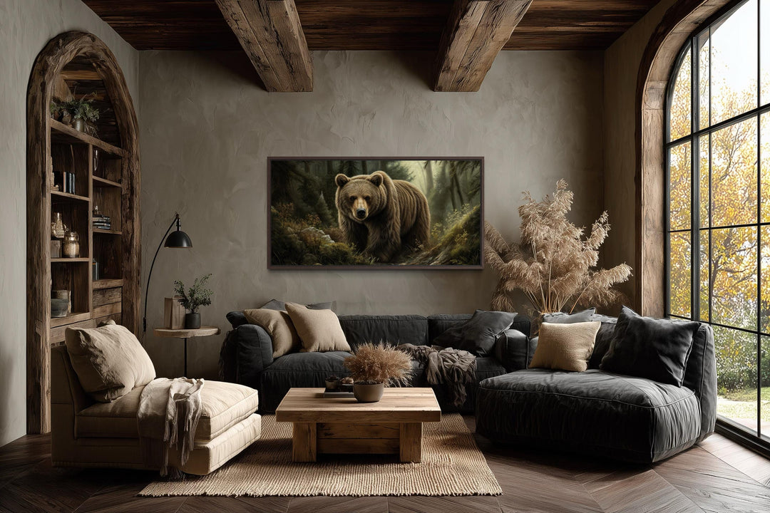 A framed canvas print of a majestic brown bear in a forest hangs in a rustic, earth-toned living room.