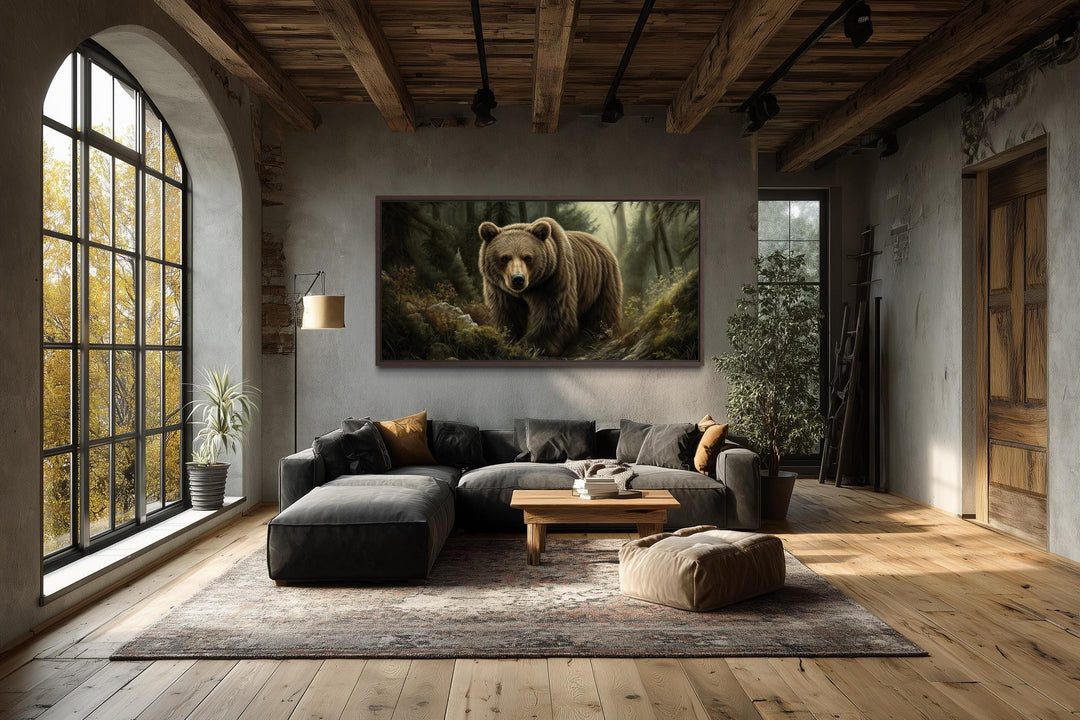 A large canvas print of a brown bear in a forest hangs in a rustic living room with wood beams.