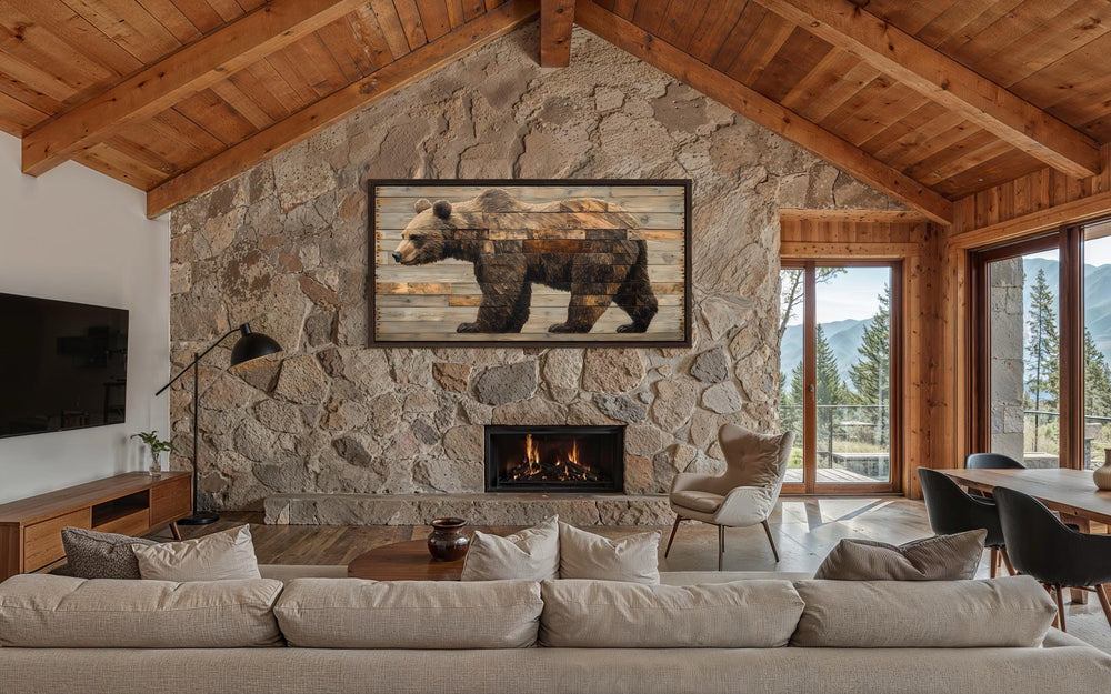 Rustic brown bear wall art on a wood-style canvas displayed above a stone fireplace in a cabin.