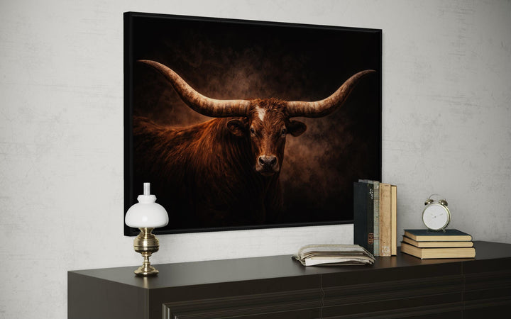 Brown longhorn bull canvas wall art with wide horns displayed above a dark wood dresser.