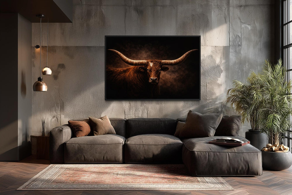 A framed canvas print of a longhorn bull with wide horns hangs above a modern sofa in a rustic room.