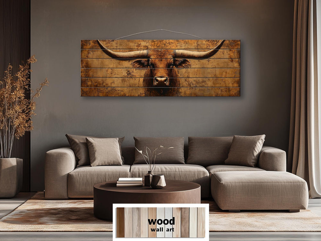 Brown longhorn steer printed on long, narrow distressed wood planks above a modern sofa.