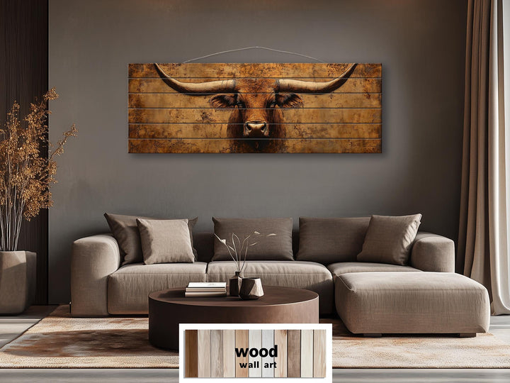 Brown longhorn steer printed on long, narrow distressed wood planks above a modern sofa.