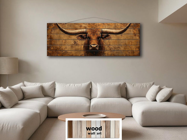 Brown longhorn steer printed on horizontal distressed wood planks above a white sectional sofa.