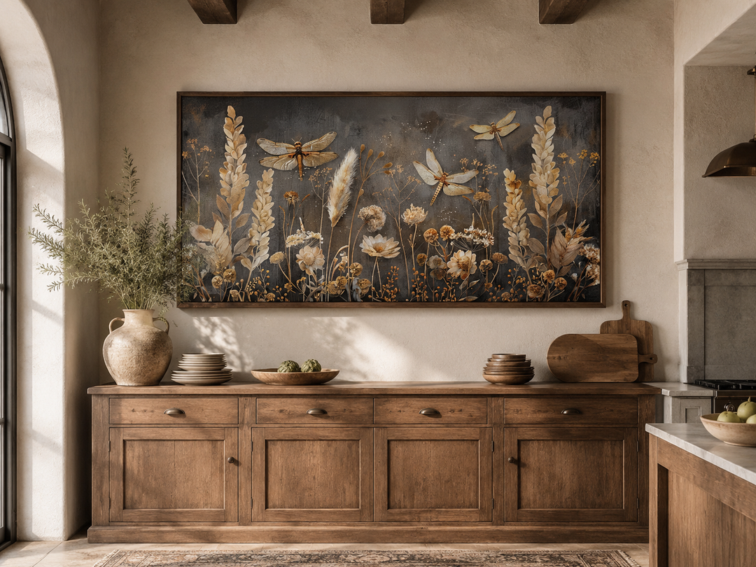 Framed horizontal canvas art of dragonflies and grasses in brown and beige over a wooden sideboard.
