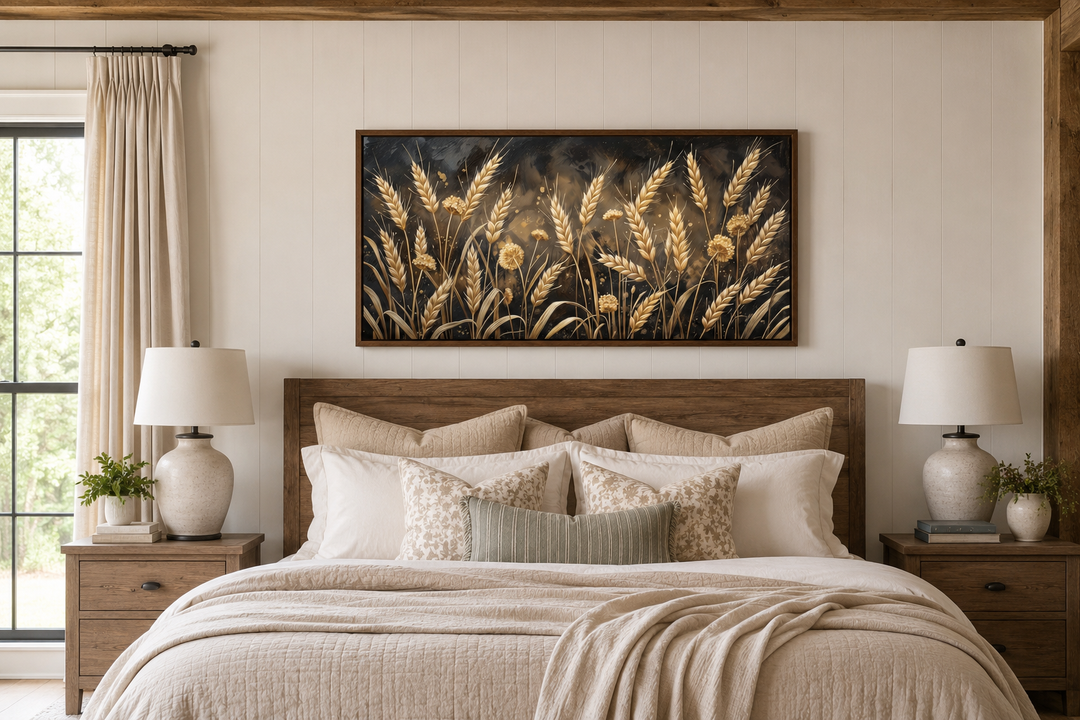 Framed horizontal canvas print of a golden wheat field above a bed in a rustic farmhouse bedroom.