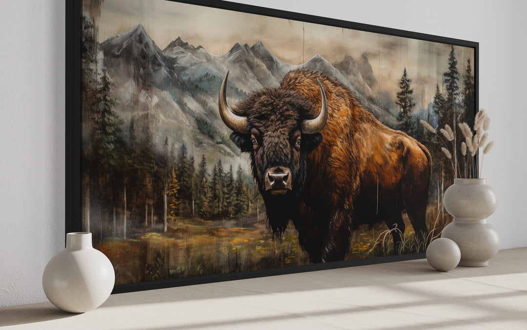 Rustic wood framed canvas of a buffalo in Yellowstone with a mountain and forest background.