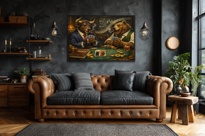 A framed canvas print of a bull and bear playing poker hangs above a brown leather chesterfield sofa.