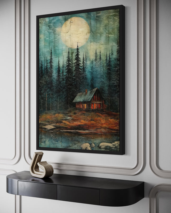 Cabin In The Woods Framed Canvas Wall Art featuring a moonlit forest scene above a black console.