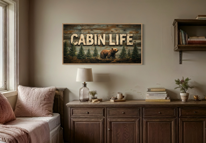 Cabin Life framed canvas wall art featuring a bear and fir trees above a rustic wooden dresser.