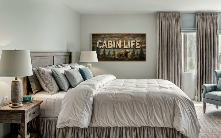 Cabin Life Sign With Bear And Fir Trees Framed Canvas Wall Art hanging above a bed in a bedroom.