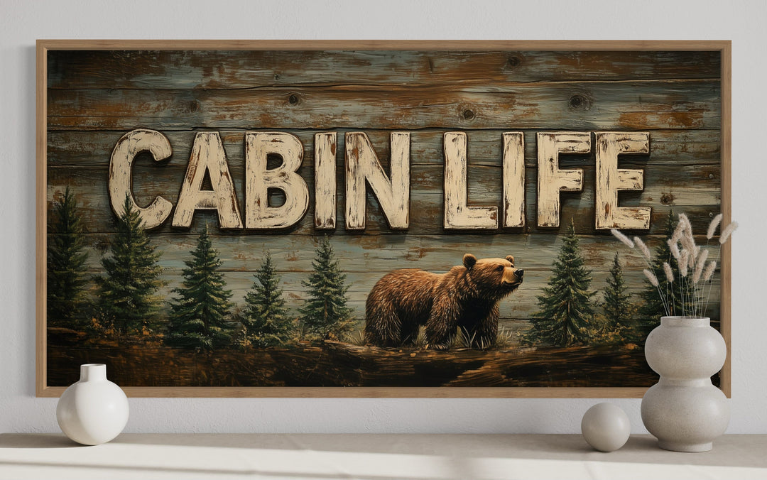 Cabin Life framed canvas wall art featuring a bear and fir trees on a rustic wood-look background.