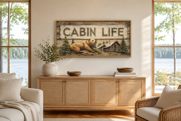 Cabin Life Sign framed canvas wall art featuring a bear and log house above a wooden sideboard.