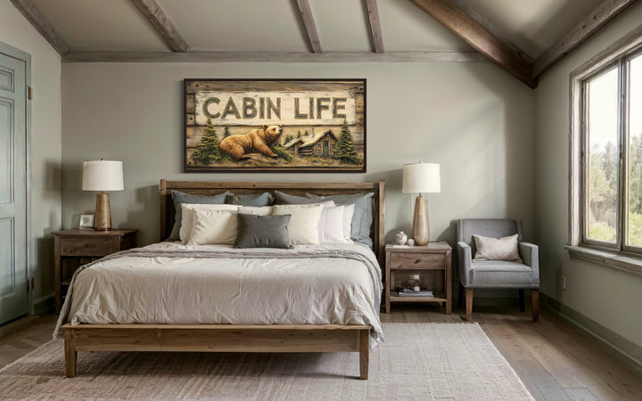 Cabin Life Sign With Log House And Bear Framed Canvas Wall Art hanging above a bed in a bedroom.