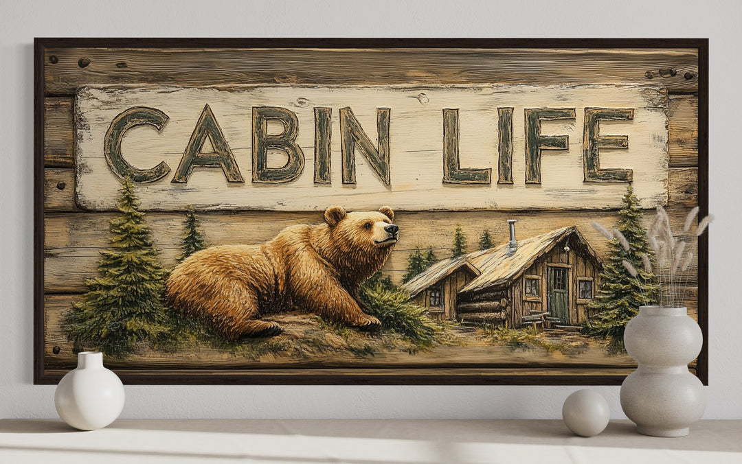 Cabin Life framed canvas wall art featuring a bear, log house, and trees on a rustic wood background.