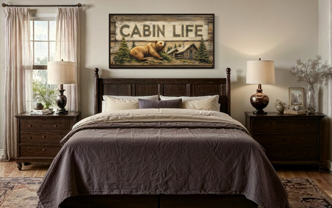 Cabin Life Sign framed canvas wall art with a bear and log house above a dark wood bed.