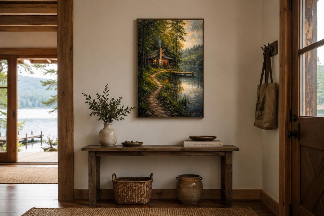 Vertical canvas print of a cozy forest cabin by a lake, hung above a rustic wooden console table.
