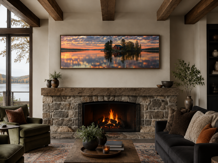 Long horizontal framed canvas art of a cabin on a lake at sunset above a stone fireplace.