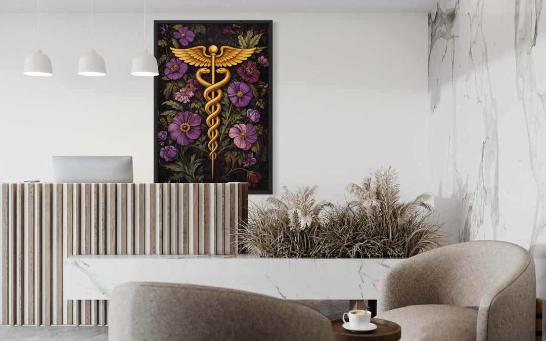 A vertical canvas print of a golden caduceus symbol surrounded by purple flowers in a modern office.