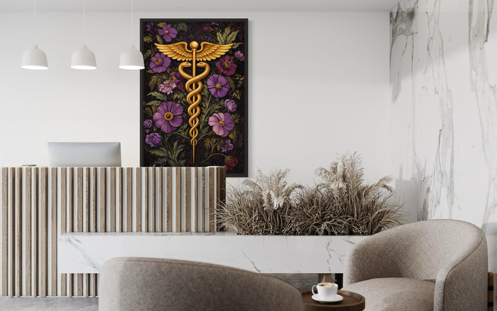 A vertical canvas print of a golden caduceus symbol surrounded by purple flowers in a modern office.