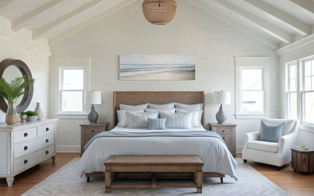 Calm long horizontal ocean framed canvas wall art in a serene bedroom with blue and white bedding.