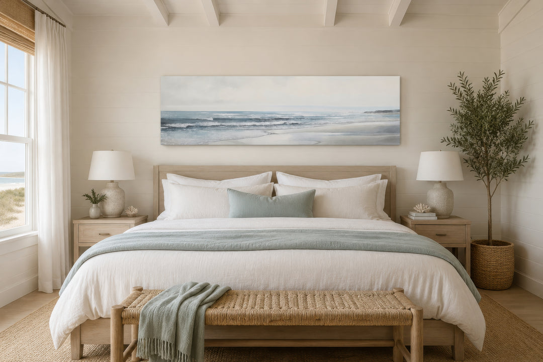 Long horizontal coastal framed canvas wall art featuring a minimalist beach landscape over a bed.